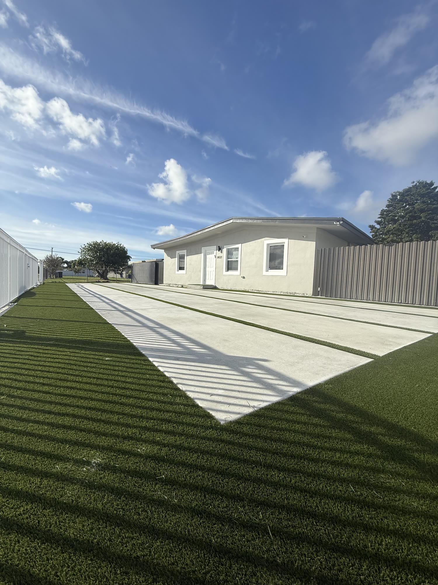 Concrete driveway and artificial turf completed as one exterior project