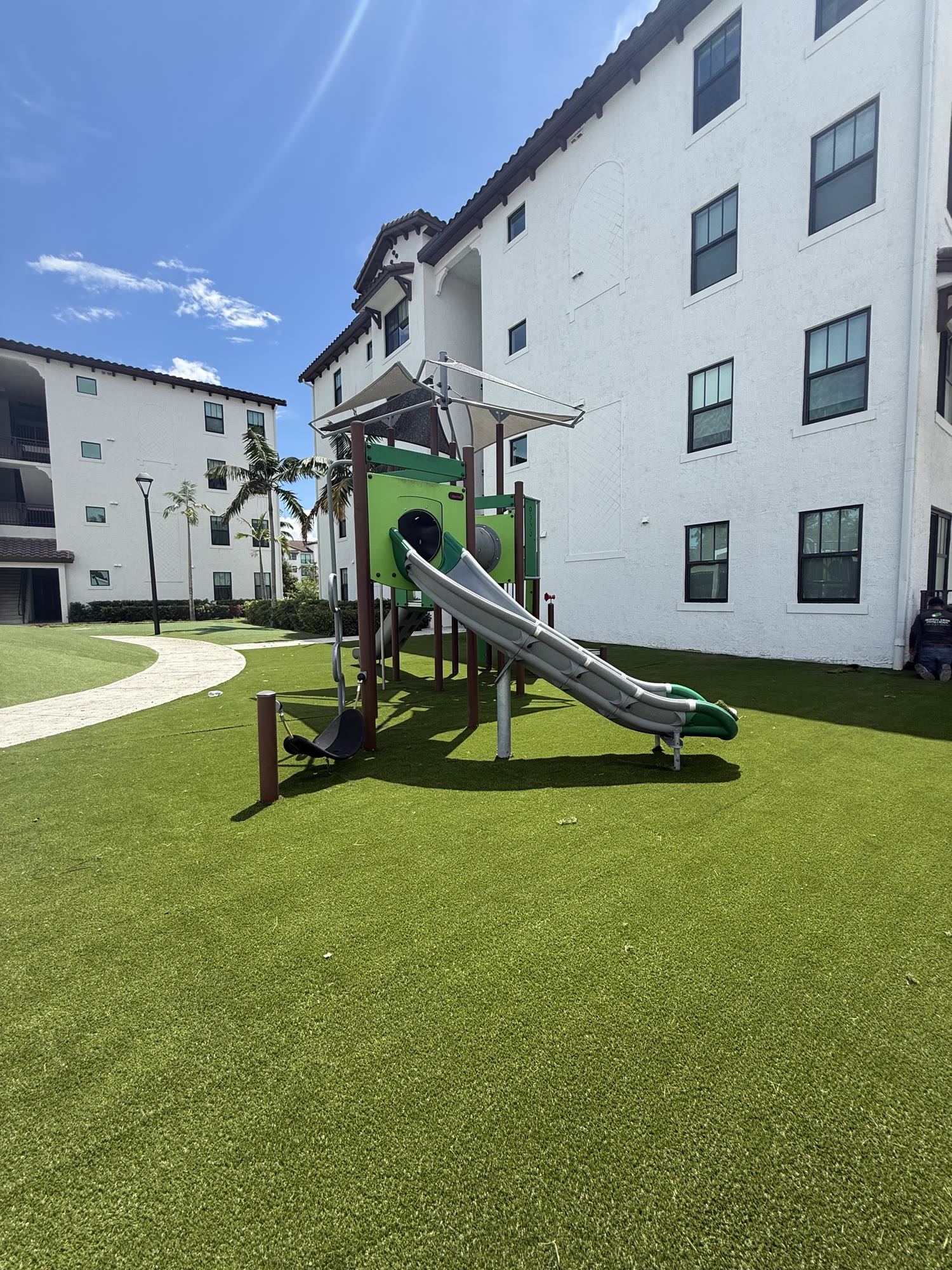 Artificial turf installed around playground equipment in a residential community